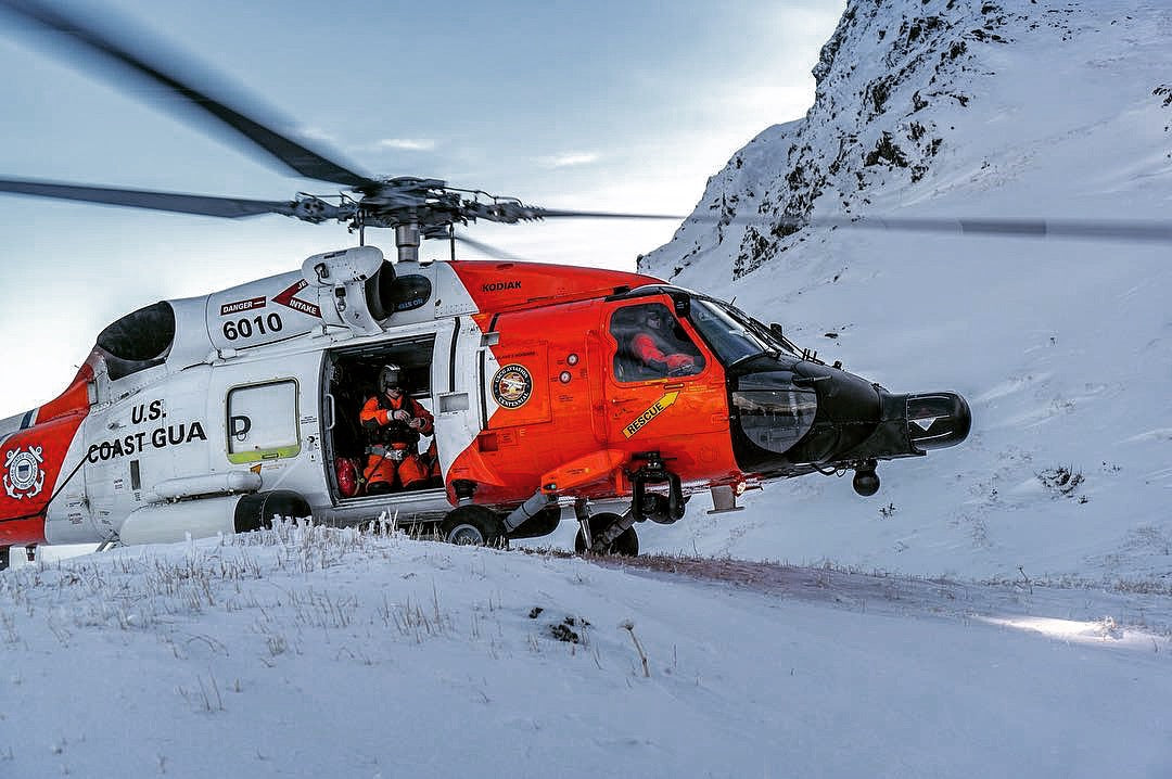 US Coast Guard MH-60 Jayhawk from Air Station Kodiak landed on snow, crew in the cabin door