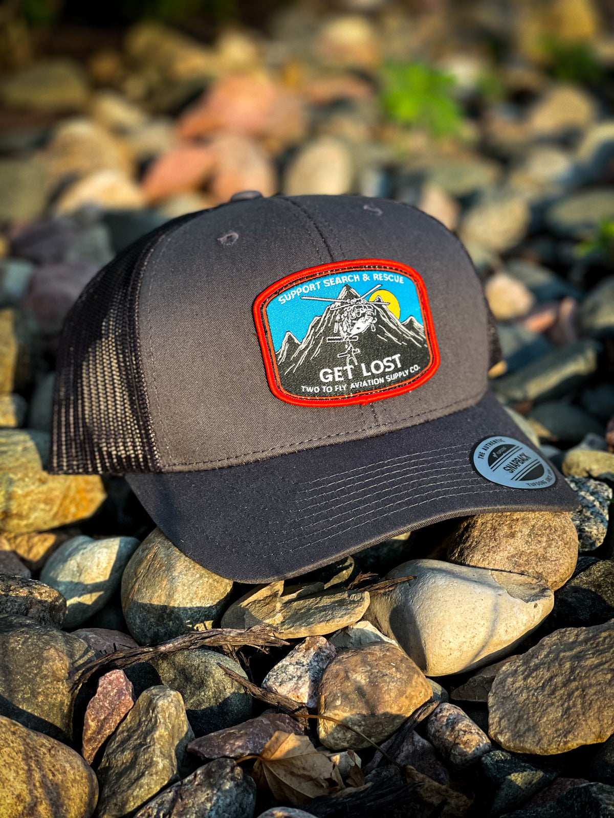 Get Lost V2 charcoal snapback trucker cap with woven Support Search & Rescue patch